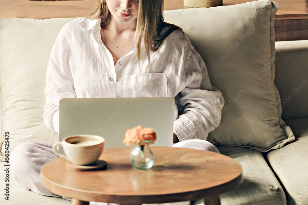 Woman with a cup of coffee working at laptop face unrecognized Woman with a cup of coffee working at laptop face unrecognized
