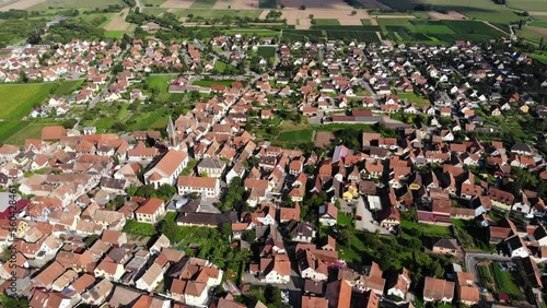 Panorama of old Kintzheim town, many small buildings with tile roofs and cozy streets. One of settlement on Alsace Wine Route, tourist attraction of Bas-Rhin, France. Air shot, camera slowly move back photo