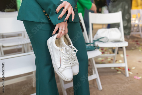 Business woman took off her black high-heeled shoes and massages her feet. Ankle pain from uncomfortable shoes.