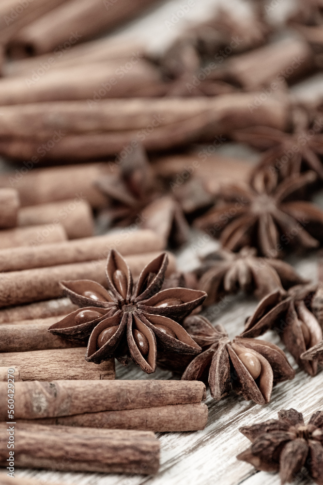 Background with cinnamon sticks, anise stars, coffee beans and nuts. Spicy trendy background. Close-up of various spices on wooden table top view Background with cinnamon sticks, anise stars, coffee beans and nuts. Spicy trendy background. Close-up of various spices on wooden table top view