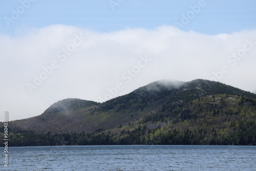 Morning fog on a mountain with a lake in the foreground