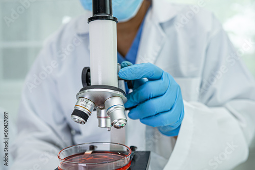 Fotografie Asian scientist biochemist or microbiologist working research with a microscope in laboratory