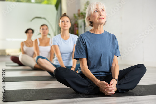 Woman making yoga meditation in lotus pose in fitness center