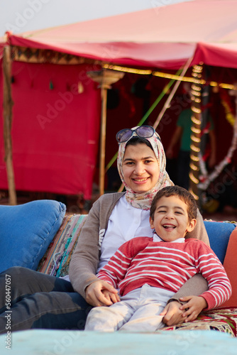 close up portrait of a beautiful young mother playing with her son at golden hour with blurry colorful background 