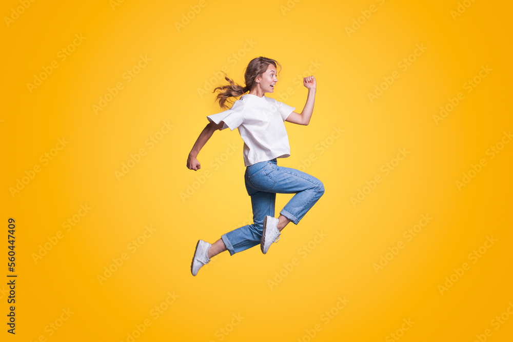 Full body young smiling happy woman hurry up isolated on yellow color background studio portrait. People lifestyle concept