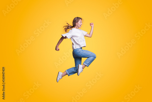 Full body young smiling happy woman hurry up isolated on yellow color background studio portrait. People lifestyle concept © Strelciuc