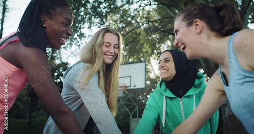 Group of Female Teenagers Stacking Their Hands Together as a Team and Ending with a Cheer and a Hug. Multiethnic Girls Gathered in a Huddle Preparing a Strategy for a Friendly Basketball Match photo