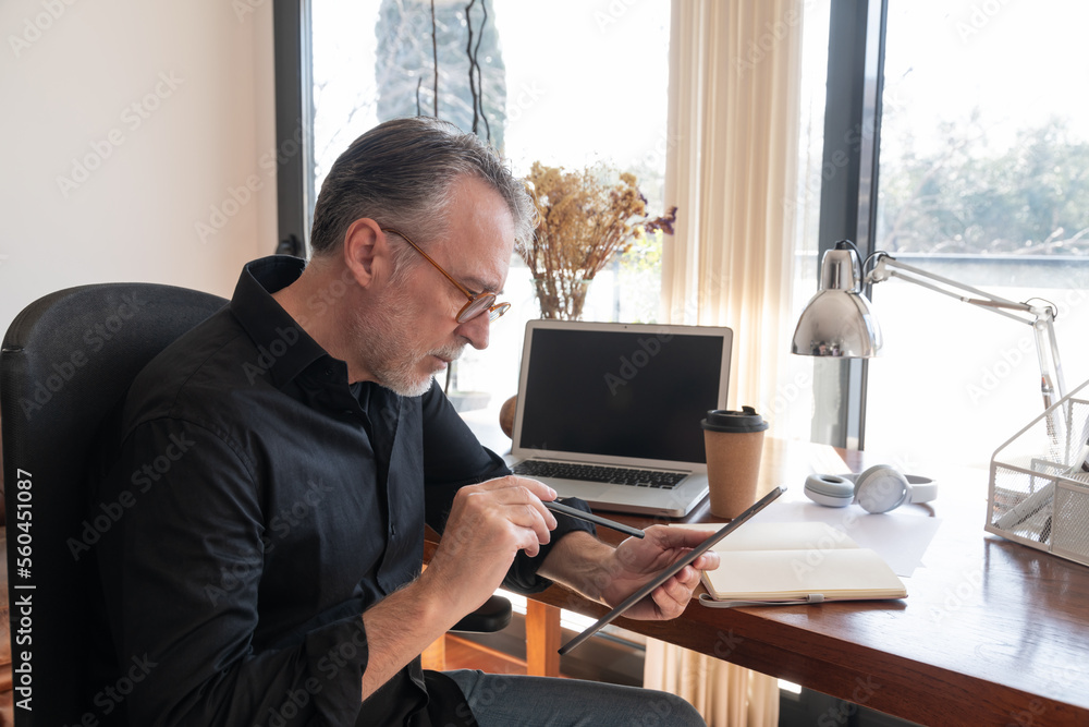 Serious man working on tablet at home Serious man working on tablet at home