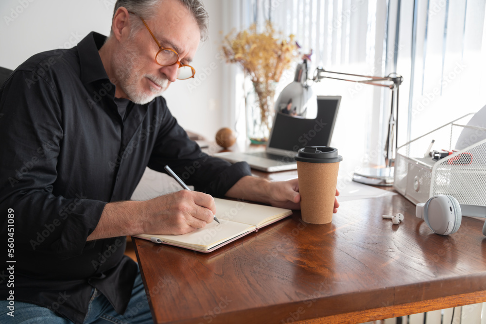 © ADDICTIVE STOCK - Focused freelancer writing in organizer at home office desk © ADDICTIVE STOCK - Focused freelancer writing in organizer at home office desk
