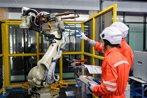 Engineer teach trainee operation maintenance and programing robot arm to work on heavy industry