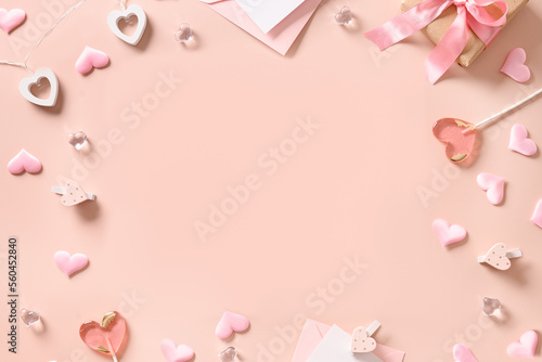 Valentine's greeting card with gift, pink lollipops, hearts on pink background. View from above. Copy space. © svetlana_cherruty