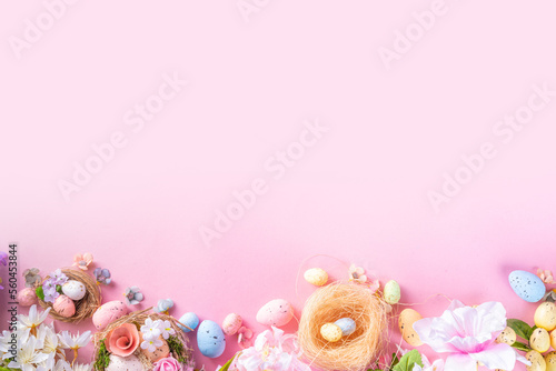 Spring Easter holiday top view flat lay background with eggs in nests and flowers. Happy Easter  greeting card background with copy space, on pastel pink background copy space