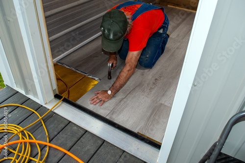 Installation of gray laminate flooring in progress photo
