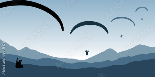 paragliding adventure flying with friends on blue mountain background at sunset