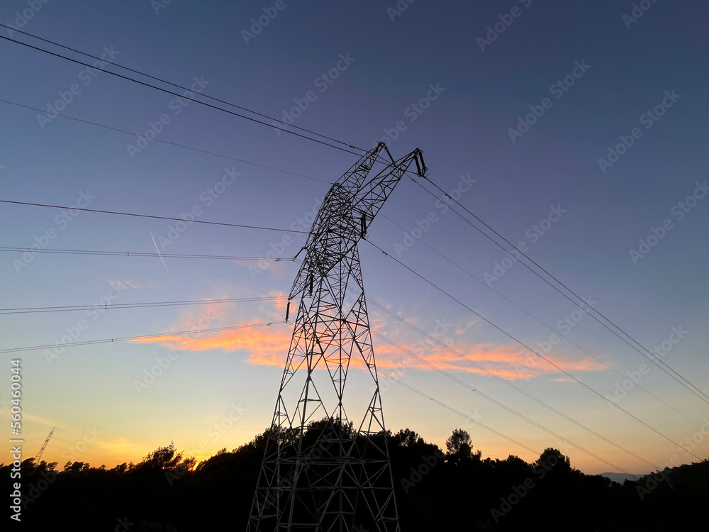 High voltage cable tower during sunset on a mountain in Barcelona in Spain