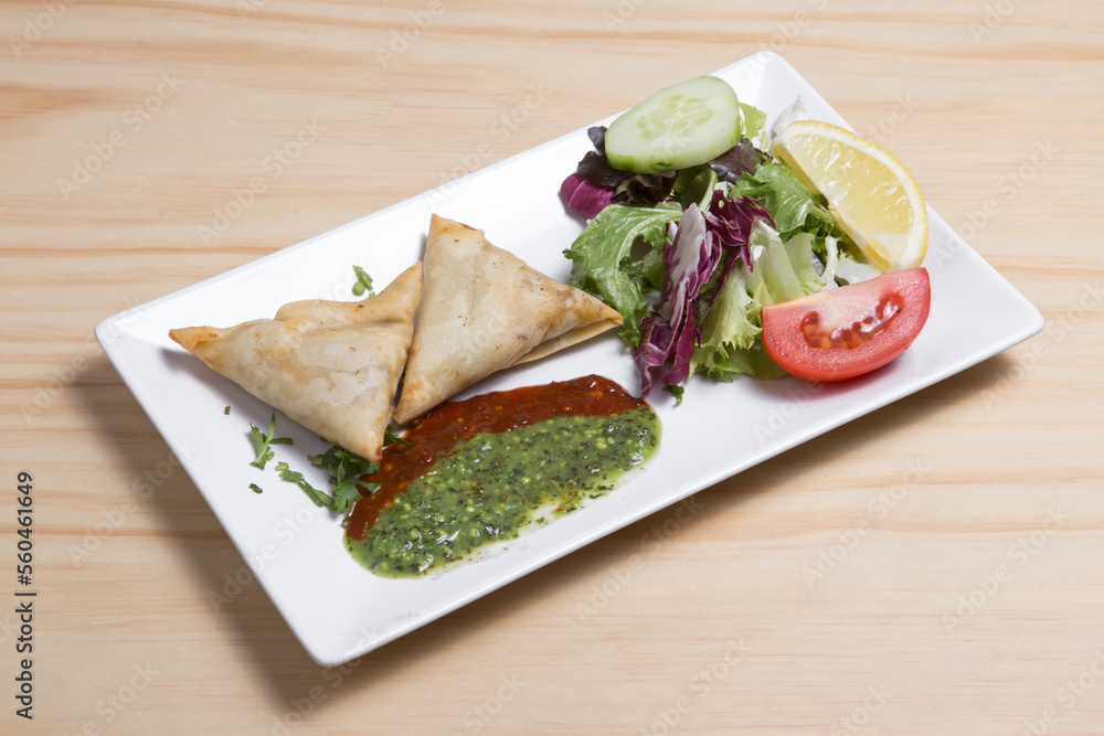 Samosa with lettuce on a wooden table