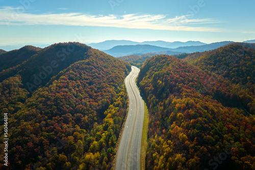 View from above of empty deserted I-40 freeway route in North Carolina leading to Asheville thru Appalachian mountains with yellow fall woods. Interstate transportation concept