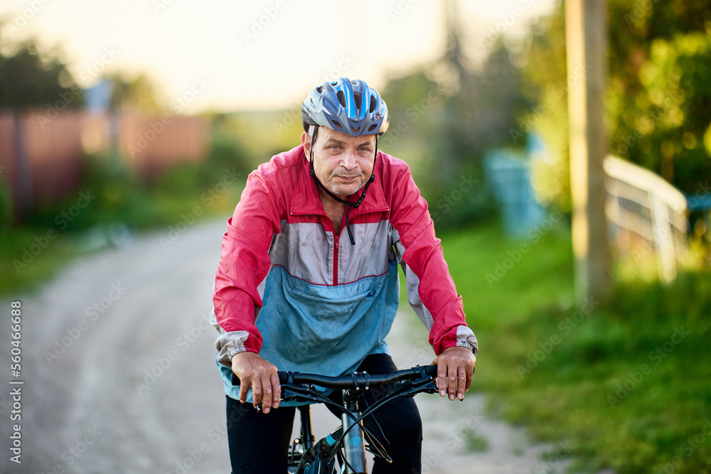 Cyclist over 60 in countryside on summer evening. Cyclist over 60 in countryside on summer evening.
