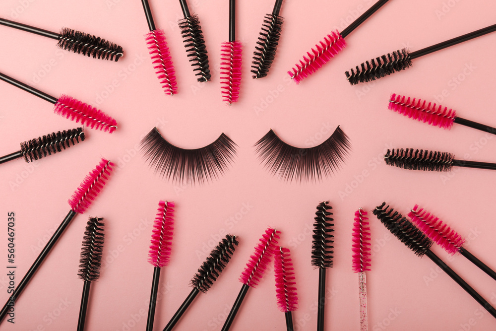 False eyelashes and an eyelash brush on a pink background close-up. Makeup. Beauty concept. Beautiful long eyelashes in a beauty salon False eyelashes and an eyelash brush on a pink background close-up. Makeup. Beauty concept. Beautiful long eyelashes in a beauty salon
