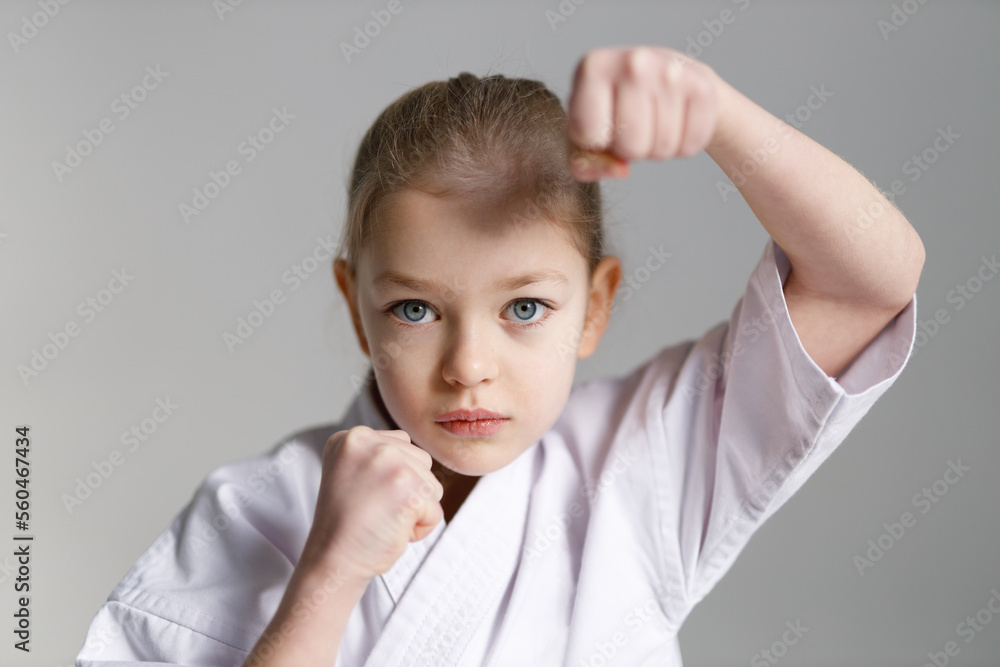 Fighting position for self-defense of a little girl in karate. Close-up, portrait. Fighting position for self-defense of a little girl in karate. Close-up, portrait.