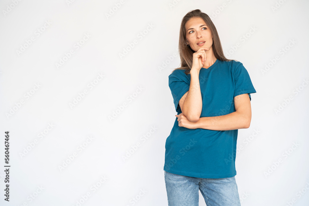 Portrait of thoughtful young woman holding her chin. Female Caucasian model with brown hair and grey eyes in casual clothes looking away making decision. Advertising concept Portrait of thoughtful young woman holding her chin. Female Caucasian model with brown hair and grey eyes in casual clothes looking away making decision. Advertising concept