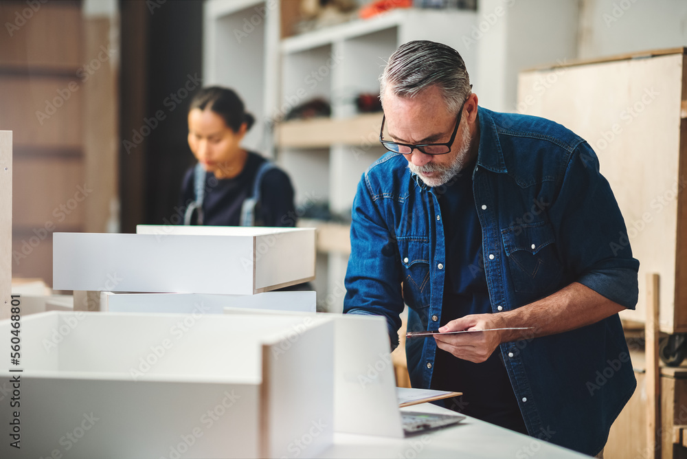Fototapeta premium Senior caucasian man specialist worker measuring white shelf furniture in wood workshop, Small business in wood furniture industry.