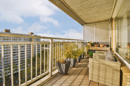 a balcony with chairs and plants on the outside deck, looking out onto the cityscapea view is in the background photo