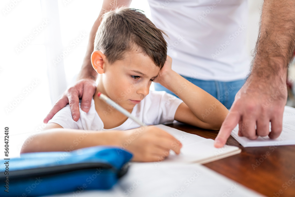 Father and son doing homework together at home Father and son doing homework together at home