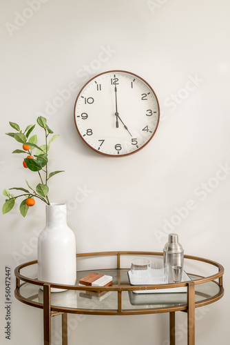 Styled Home Still Lifestyle Image. Side Table with Wall Clock and Vase with Eucalyptus Leaves.