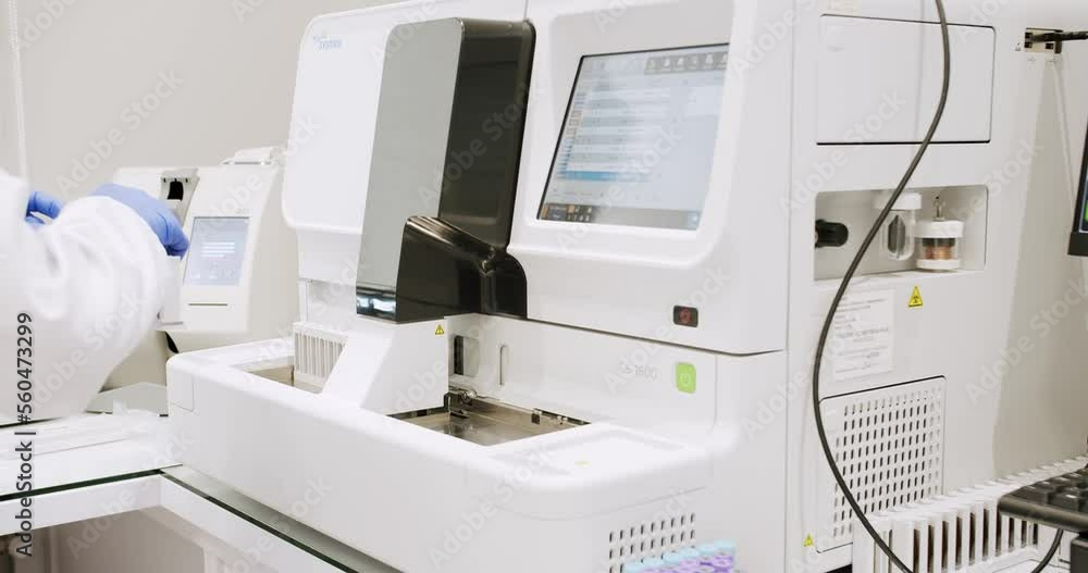 Blood Testing Machine Checks Samples In A Laboratory Room. Automated machine in work process, blood and urine sampleanalysis. Bio lab medical clinic chemical automatic analyzer. Blood Testing Machine Checks Samples In A Laboratory Room. Automated machine in work process, blood and urine sampleanalysis. Bio lab medical clinic chemical automatic analyzer.
