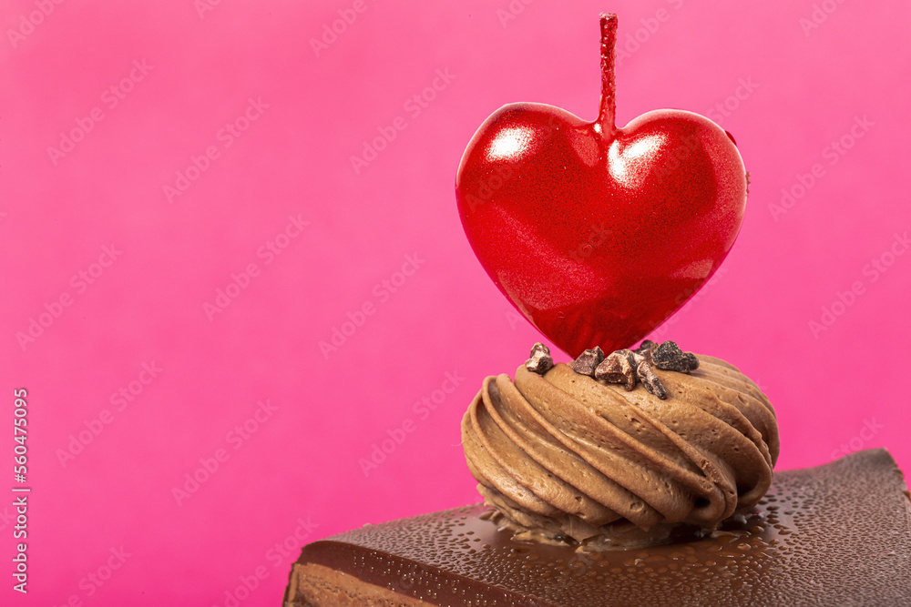 Fototapeta premium Background of chocolate cake with heart candle for Valentine's Day