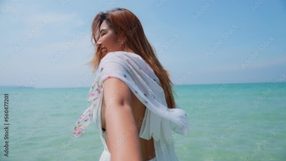 Back view of sexy asian woman holding boyfriend hand and running on tropical beach to the sea on a holiday. An excited woman run and pulls her man hand to the beach on a summer day. Follow me. Back view of sexy asian woman holding boyfriend hand and running on tropical beach to the sea on a holiday. An excited woman run and pulls her man hand to the beach on a summer day. Follow me.