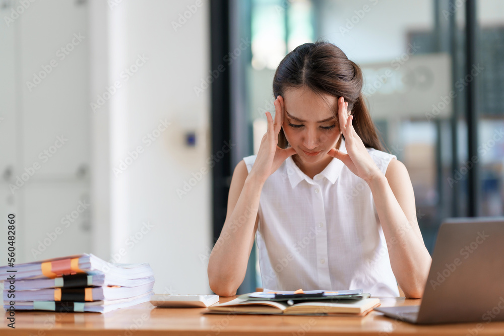 Asian businesswoman feeling tired and exhausted, headache stressed with overwork and unsuccessful work in the office. Asian businesswoman feeling tired and exhausted, headache stressed with overwork and unsuccessful work in the office.