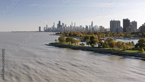 Panning in aerial drone view of the Chicago skyline from Lake Michigan near Belmont harbor on a sunny blue sky fall day.
