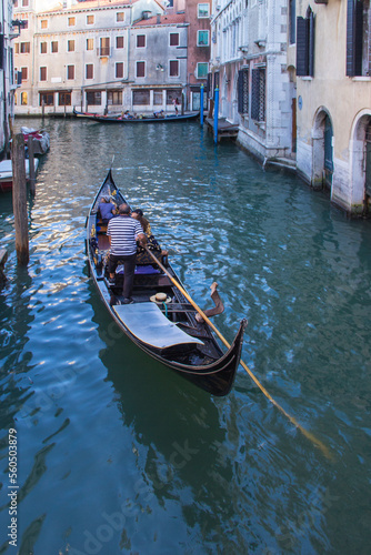 Venice - August 27: Gondolier drives a gondola with tourists on board on the Grand Canal on August 27, 2018 in Venice, Italy