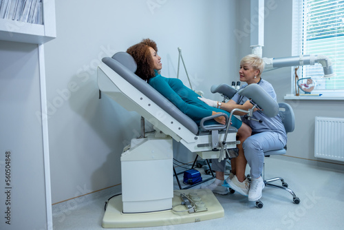 Curly-haired woman having an examination at the gynecologist office photo