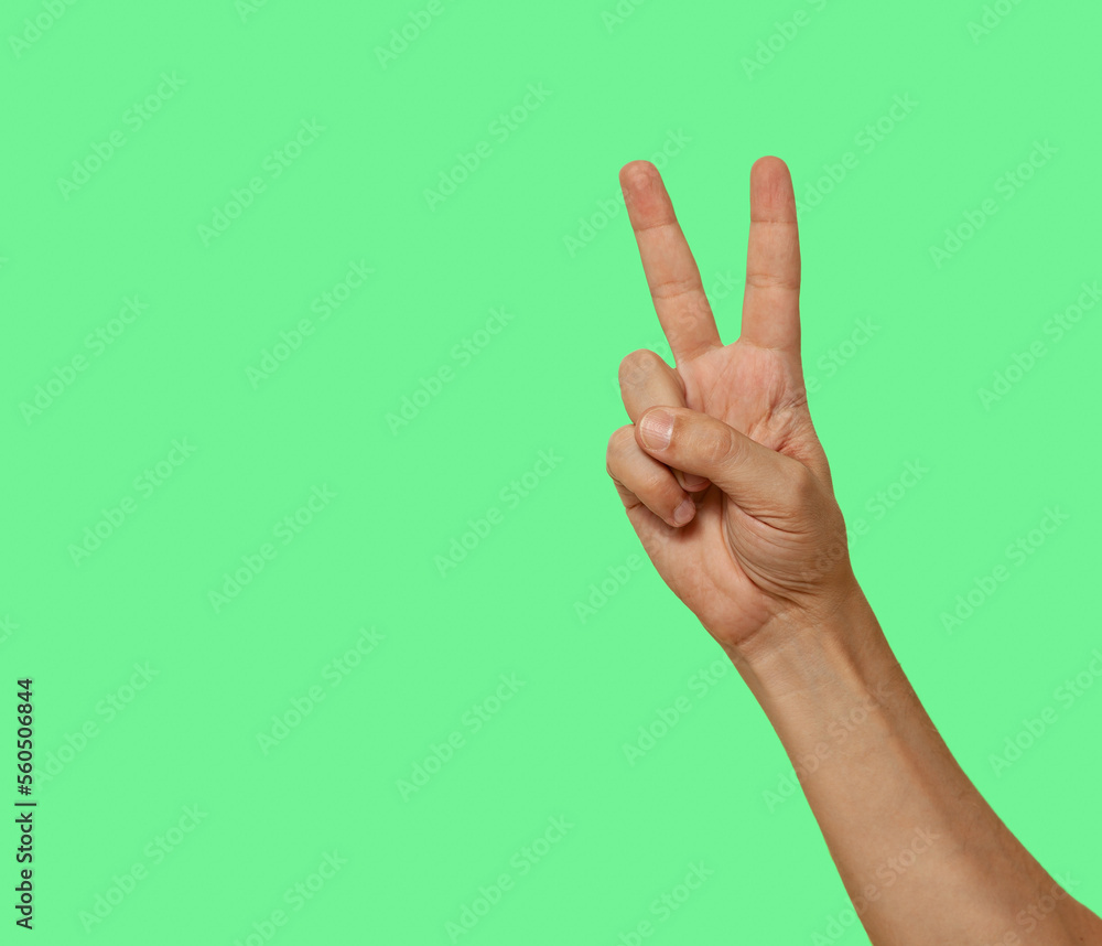 Two fingers raised up isolated on green screen background..