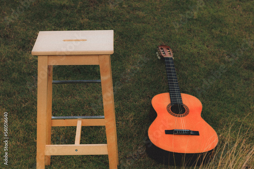 Acoustic guitar and high chair on a grasspatch photo