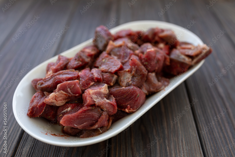 Diced and pickled raw boar meat in spices, soft focus Diced and pickled raw boar meat in spices, soft focus