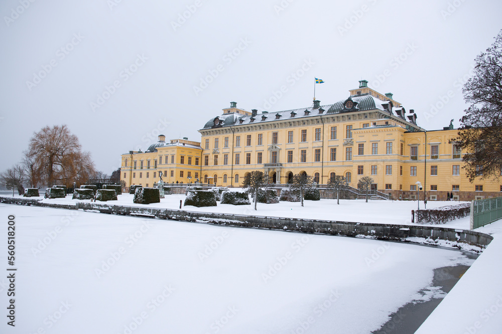 View of Drottningholm Palace from the gardens in winter. It is the residence of the Swedish royal family and is located near the capital Stockholm, Sweden. The park is covered in snow.