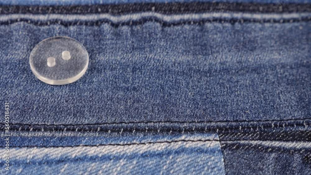 Plastic transparent buttons fall on denim. Plastic transparent buttons fall on denim.