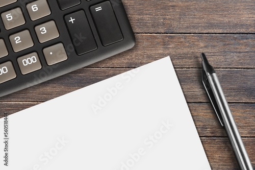 Blank paper and calculator on office desk photo