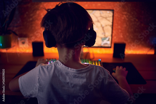 Boy playing shooter online video game - Technology trend concept - Main focus on headphones
