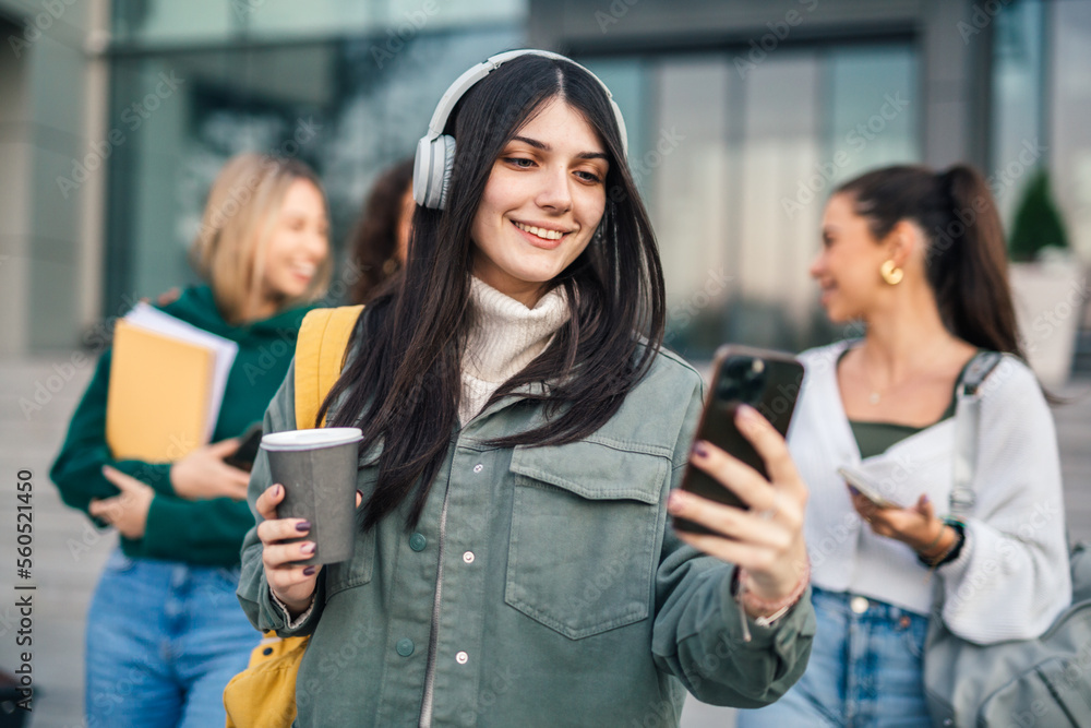 Young college student is taking a picture of herself using front camera