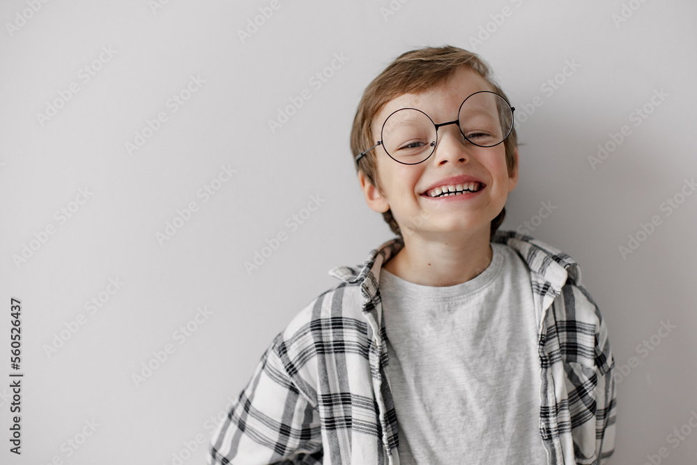 Happy school boy with big smile. Pupil in glasses on grey background. Home education.