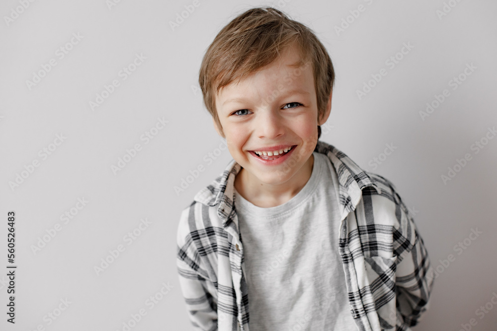 Happy little boy smiling to the camera. Grey studio background. Happy little boy smiling to the camera. Grey studio background.