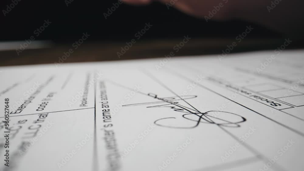 Close-up of hand of unrecognizable person signing a document by ballpoint pen, concluding contract Close-up of hand of unrecognizable person signing a document by ballpoint pen, concluding contract