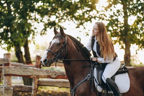 A young female jockey is sitting on her horse in show jumping training. Preparing for the competition.