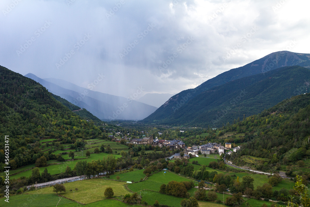 view of rain over a spanish town in a green valley