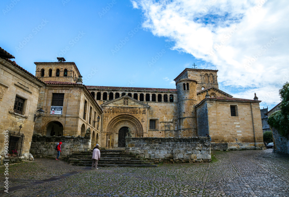 People visiting an old church of Colegiata de santa Juliana, with a beautiful blue cloudy sky